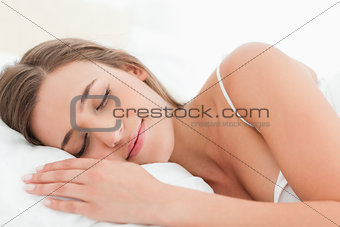 Woman in bed, sleeping and smiling softly