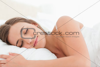 Woman sleeping in bed, her head on the pillow