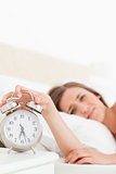 Woman silencing her alarm clock with her hand