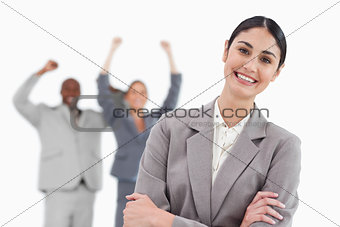Smiling saleswoman with cheering co-workers behind her