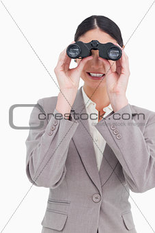 Businesswoman looking through binoculars