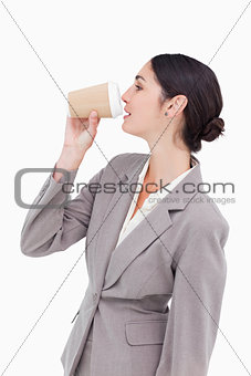 Side view of businesswoman taking a sip out of a paper cup