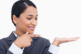 Close up of smiling saleswoman pointing and looking at her palm