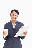 Close up of smiling saleswoman with paper cup and newspaper