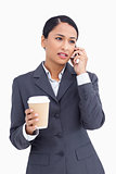 Close up of saleswoman with paper cup talking on cellphone