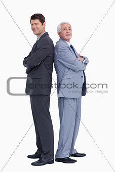 Smiling businessmen standing back to back