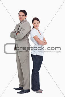 Serious salesteam with arms folded standing back to back