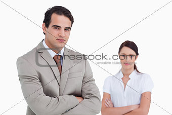 Salesman with arms crossed and colleague behind him
