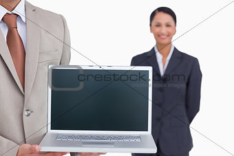 Laptop being presented by salesman with colleague behind him