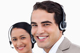 Close up side view of smiling call center agents at work