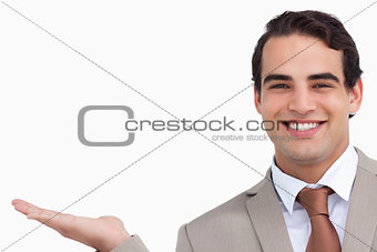 Close up of smiling salesman holding palm up
