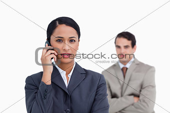 Saleswoman on her cellphone with colleague behind her