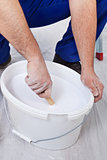 Worker stirring the paint - closeup on hands