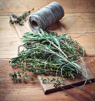 Fresh thyme and rosemary on wooden board