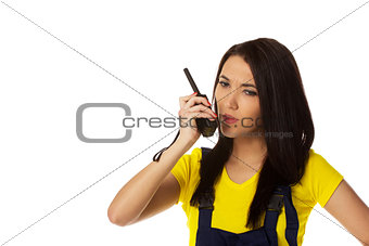 serious female construction worker talking with a walkie talkie 