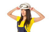 Serious female construction worker in helmet with goggles