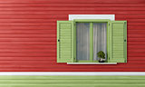 Green windows on red wooden wall