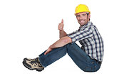 Builder sat down giving thumbs-up