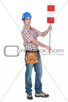 Worker holding up road sign