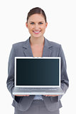 Smiling tradeswoman presenting screen of her laptop