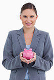 Smiling bank clerk holding piggy bank