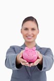 Piggy bank being offered by smiling bank clerk
