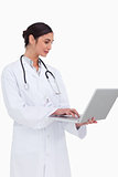 Side view of female doctor working on her laptop