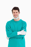 Close up of smiling male doctor in scrubs with folded arms