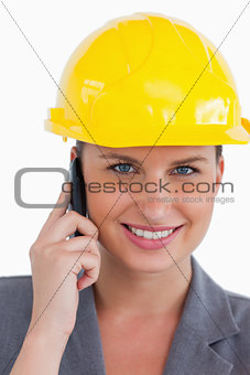 Close up of female architect with helmet on her cellphone