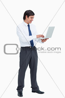 Side view of smiling tradesman working on his laptop