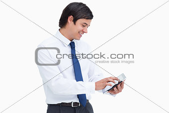 Side view of smiling tradesman using his tablet computer