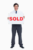 Smiling male real estate agent with sold sign