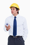 Male architect with helmet and plans looking to the side