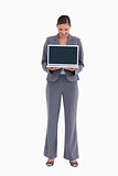 Tradeswoman presenting and looking at laptop screen