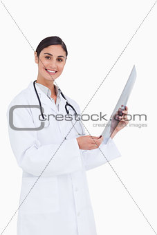 Side view of smiling female doctor with x-ray
