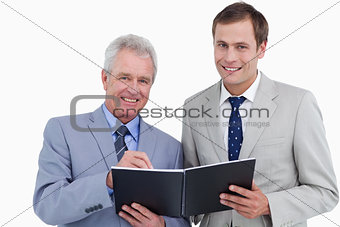 Smiling tradesmen taking notes in order book
