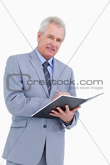 Smiling mature tradesman with pen and notebook