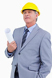 Mature architect wearing helmet and holding plans