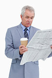 Surprised mature tradesman with news paper and paper cup
