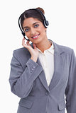 Smiling female call center agent adjusting her headset