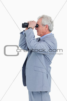 Side view of mature tradesman looking through spy glass