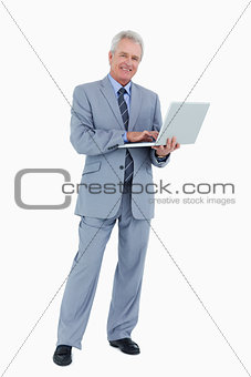 Smiling mature tradesman with his laptop