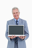 Smiling mature tradesman presenting screen of his laptop