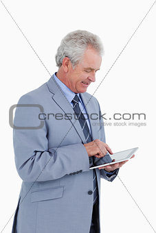 Side view of smiling mature tradesman using tablet computer