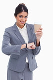 Smiling female entrepreneur with paper cup just checked the time