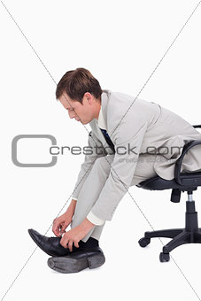 Side view of businessman fastening his shoes