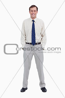 Smiling young businessman with his hands in his pockets