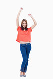 Laughing teenage wearing casual clothes while raising her arms