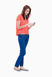 Teenage girl standing upright while sending a text 