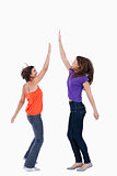 A teenage girl keeping her hand in the air while her best friend